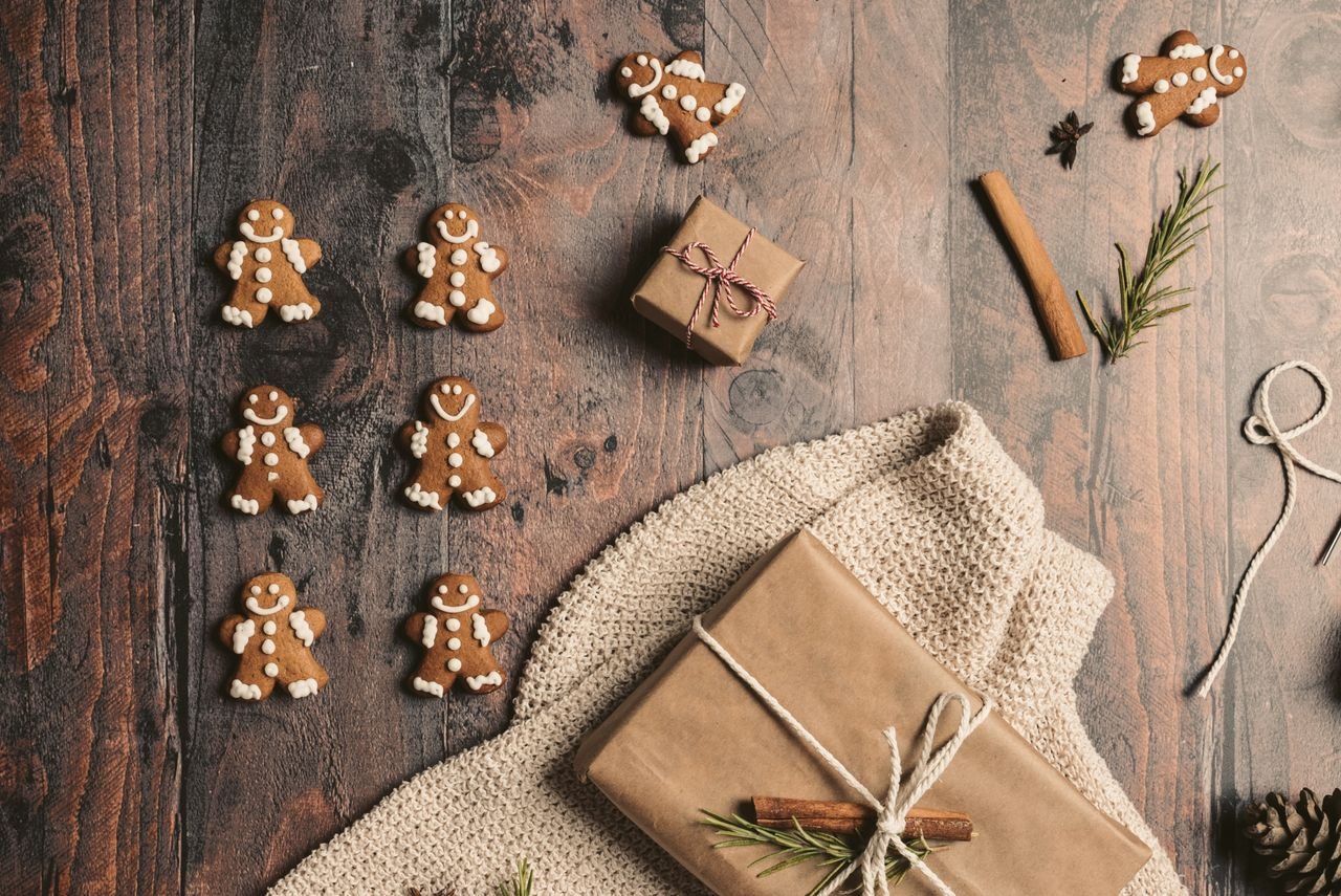 Kraft paper gifts wrapped with twine and gingerbread cookies on a rustic wood surface — affordable long distance relationship gift ideas under $25